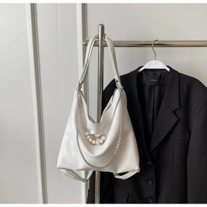 Detailansicht der weißen Hobo-Tasche mit Silberkette und Perlen-Schleifen-Anhänger