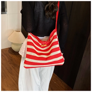Detailed texture of red and beige striped woven tote bag with wooden horn button closure