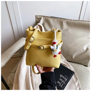 Détail du sac seau jaune à motif litchi avec un joli pendentif en forme de canard