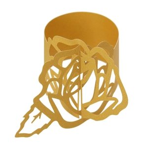 Detail of laser-cut gold rose napkin ring made of pearlescent paper for wedding decor