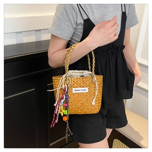 Detail of hand-woven straw bag with colorful ethnic tassels and drawstring lining