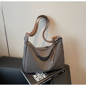 Detail der grauen Canvas-Tasche mit braunem Lederbesatz und TCT Stickerei-Logo