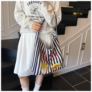 Détail du sac cabas en toile rayé bleu et blanc avec broderie frites et hamburger