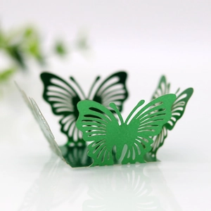 Close-up of green hollow butterfly wedding favor box with intricate laser-cut floral details