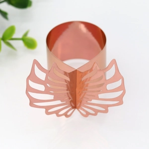 Detail of rose gold butterfly napkin ring with hollow wings and smooth metallic finish