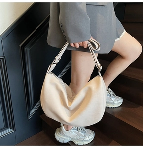Close-up of cream hobo bag showing litchi grain texture and adjustable shoulder strap
