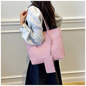Detail of pink and white chevron tote bag with matching zipper pouch on model