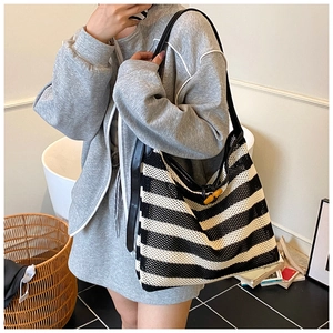 Detailed view of striped knit tote bag with vintage bamboo buckle on shoulder strap