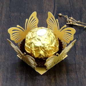 Dettaglio del porta cioccolato a farfalla dorata tagliata al laser per decorazioni nozze