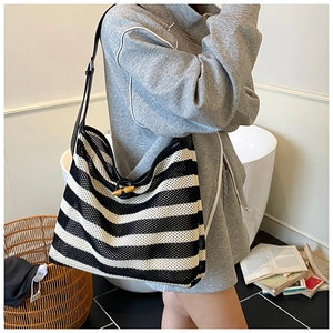 Detail showing woven black and white striped knit texture with wooden toggle closure