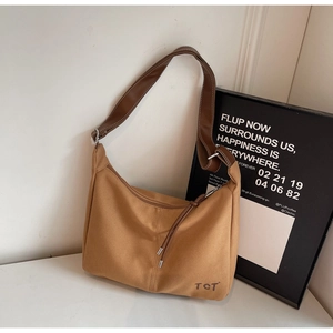Detailansicht der Khaki-Canvas-Tasche mit Lederriemen und geprägtem TCT-Markenlogo