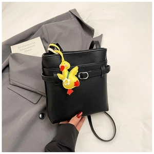 Détail du sac seau noir grainé avec pendentif canard jaune et accessoires en argent poli