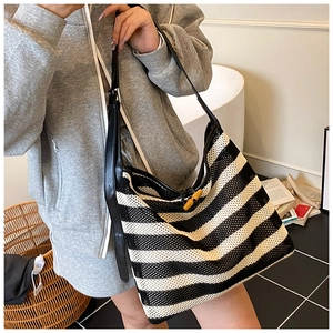 Detail of striped tote bag featuring woven texture and a wooden toggle closure button