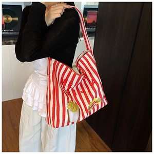 Détail du sac cabas en toile à rayures rouges avec broderies de nourriture et large bandoulière