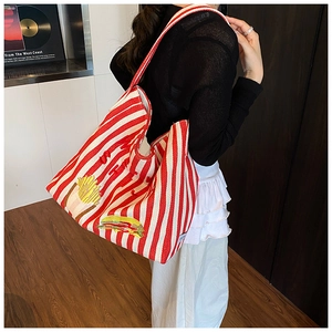 Détail du sac cabas en toile à rayures rouges et blanches avec écussons brodés