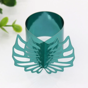 Detail of teal metallic napkin ring with creative openwork wing design and mirror finish