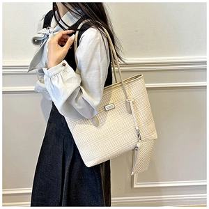 Detail of minimalist cream tote bag with chevron pattern and matching small pouch