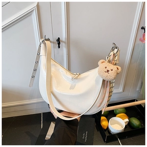 White faux crocodile hobo bag with adjustable strap and cute brown plush bear charm detail