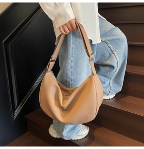 Detail of khaki pebbled leather hobo bag showing the texture and adjustable strap