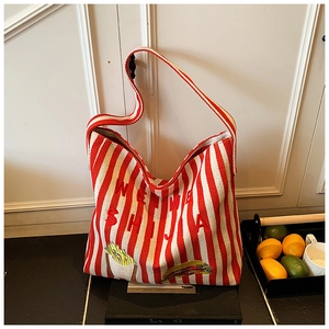 Détail du sac cabas en toile rayé rouge et blanc avec broderie WE SHI JIA et motifs floraux
