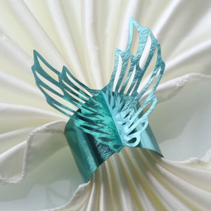 Detail of teal butterfly wing napkin ring with intricate hollow laser-cut design