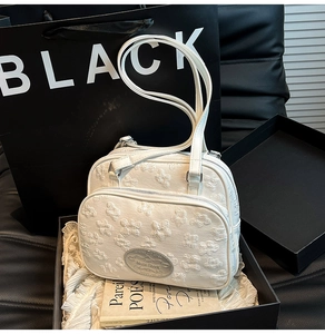 Vue détaillée du sac cabas crème en tissu gaufré floral avec logo de marque en métal