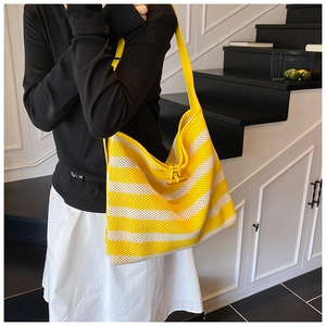 Detail of yellow and white striped knit tote bag featuring a distinct wooden toggle closure