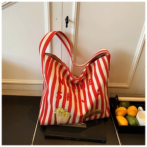 Détail du sac cabas en toile à rayures rouges avec lettres et motifs brodés