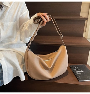 Close-up of the beige lychee pattern leather shoulder bag with adjustable strap and silver buckle