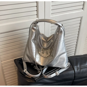 Silberne Hobo-Tasche mit Faltenstruktur, Metallschleife und Perlenanhänger-Detail