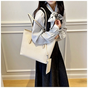 Detail view of large herringbone tote bag with matching mini pouch and leather straps
