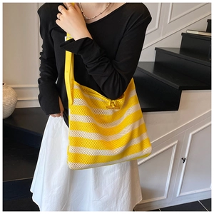Detail view of woven striped tote bag featuring wood buckle and adjustable leather strap