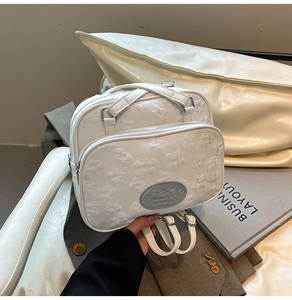 Détail d'un mini sac à dos blanc en jacquard floral avec logo métallique Moon Shark chic