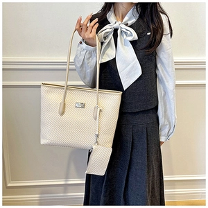Detail of large tote bag in beige herringbone pattern with matching zipped coin purse