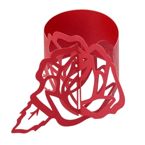 Macro view of red laser-cut paper napkin ring with hollowed rose floral design for weddings