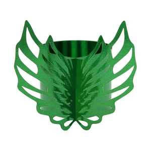 Macro detail of green metallic palm leaf napkin ring with intricate hollowed-out design
