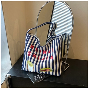 Détail du sac cabas en toile rayée avec broderie de lettres et patchs de nourriture