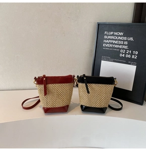 Detailed view of woven straw mini bucket bags with leather trim and shoulder straps
