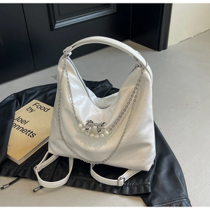 Details der weißen glänzenden sichelförmigen Tasche mit silberner Schleife und Perle