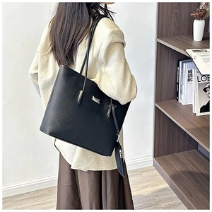 Detail of black tote bag with woven texture leather and detachable mini pouch accessory