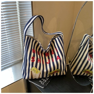 Détail du sac cabas en toile à rayures bleues avec broderie rouge et écussons food