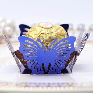 Macro view of blue laser-cut butterfly chocolate wrapper on white porcelain plate