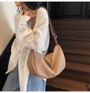 Detail of khaki hobo bag with lychee leather texture and adjustable wide shoulder strap