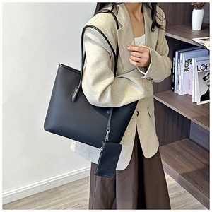 Detail view of the black textured tote bag set with matching small zipper pouch