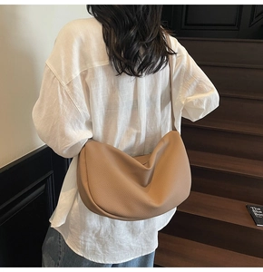 Detail view of large camel hobo bag in litchi leather worn over the shoulder