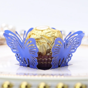 Macro shot of dark blue laser-cut butterfly wrapper with a chocolate inside for weddings