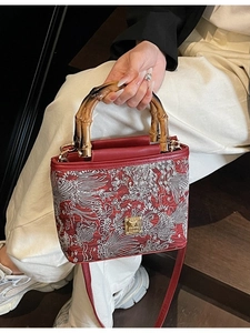 Red embroidered Chinese style bucket bag with bamboo handles and phoenix patterns