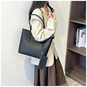 Detail of the black tote bag and matching pouch showing the textured faux leather finish