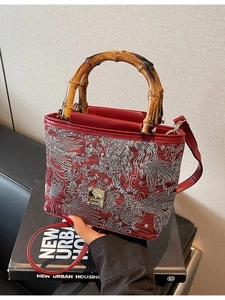 Red retro bucket bag with intricate floral embroidery and bamboo handle for women
