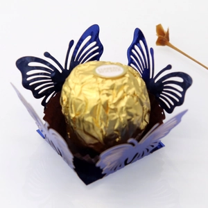 Close-up of laser-cut hollow butterfly paper candy box in dark blue with floral decor